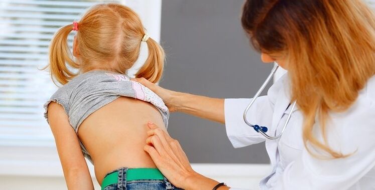 Medico che esamina la schiena di un bambino per individuare il mal di schiena